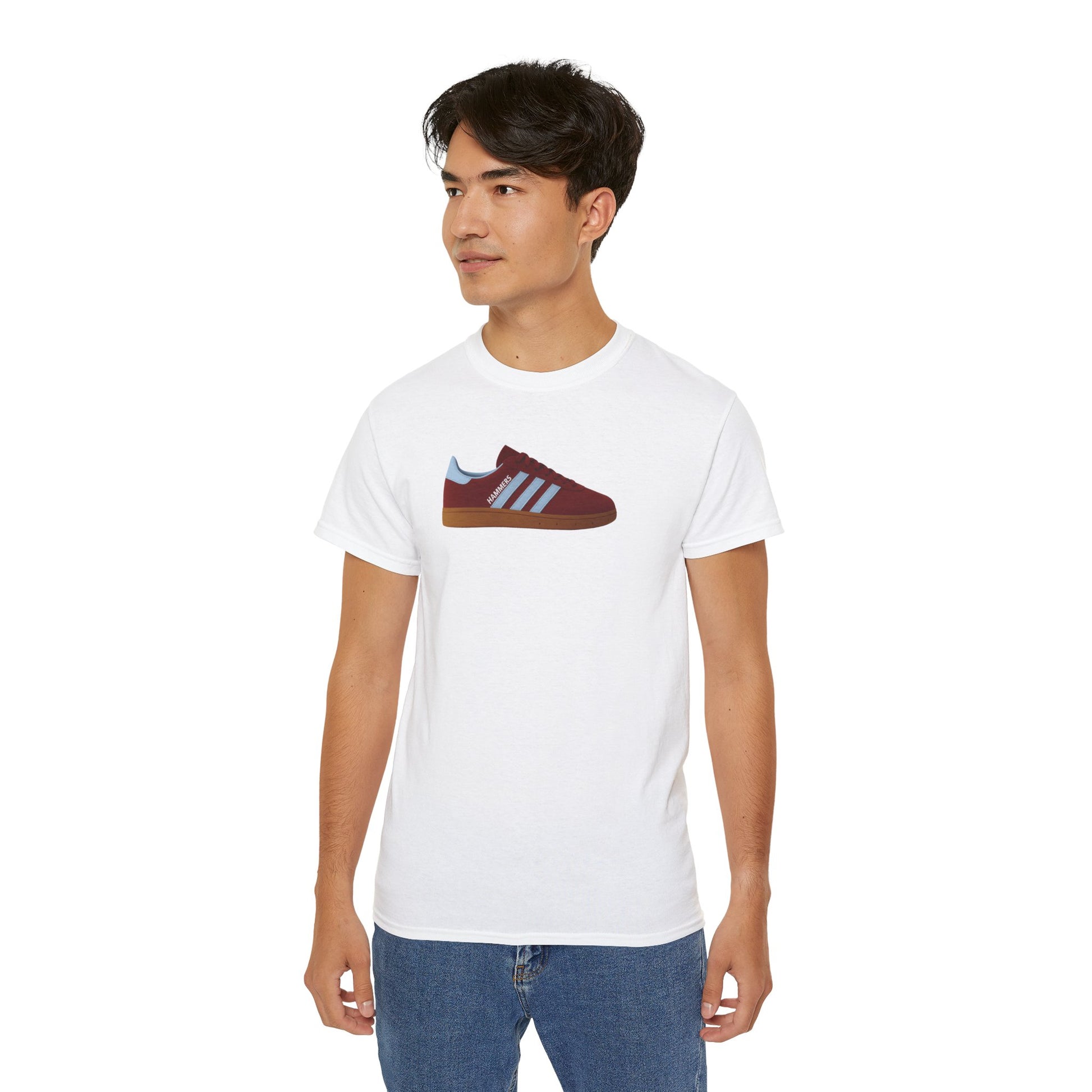 Man wearing white t-shirt with maroon and blue sneaker graphic and blue jeans on white background