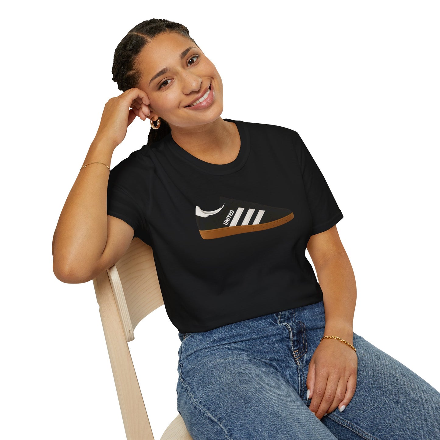 Smiling woman sitting on wooden chair wearing black t-shirt with sneaker graphic and blue jeans