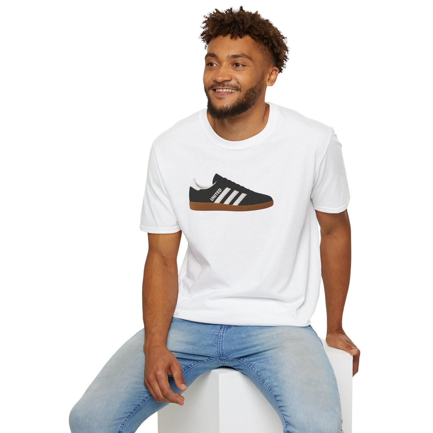 Smiling man sitting wearing white t-shirt with black sneaker graphic and light blue jeans on white background