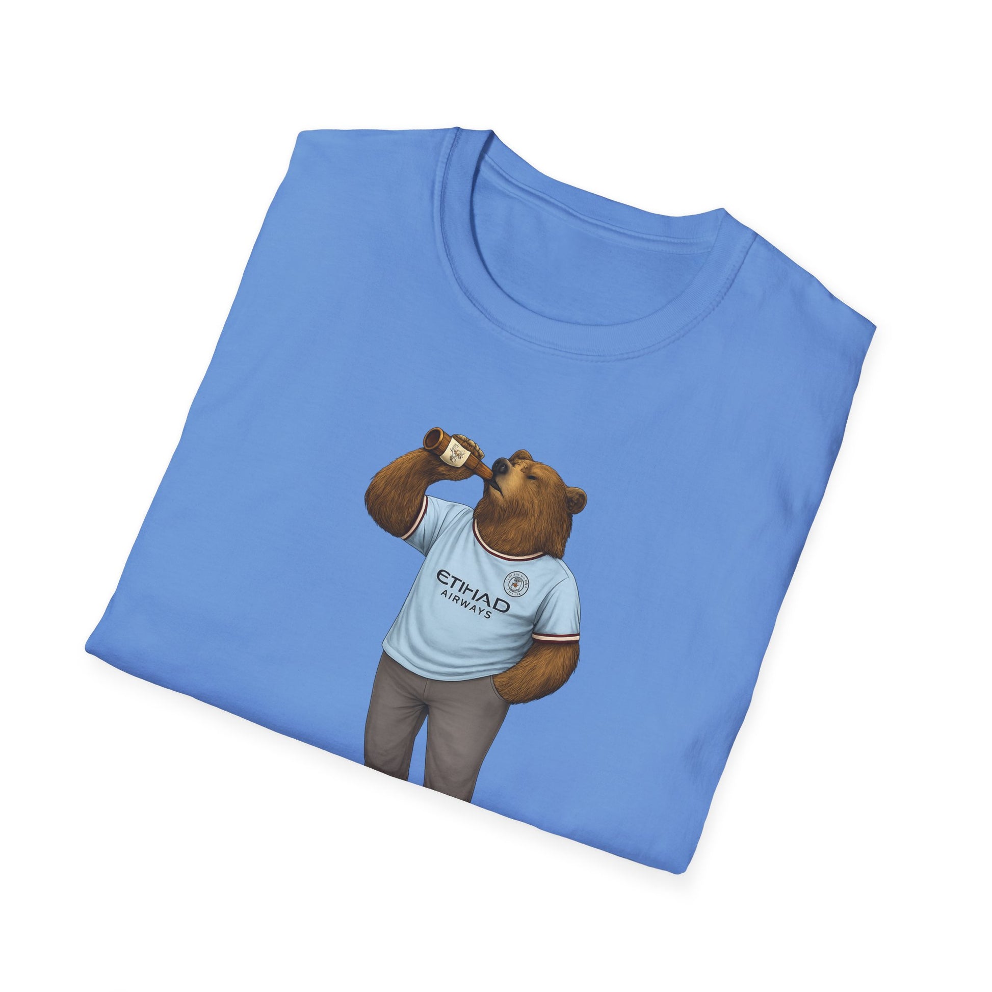 Light blue t-shirt featuring a bear wearing a Manchester City football jersey drinking from a bottle illustration