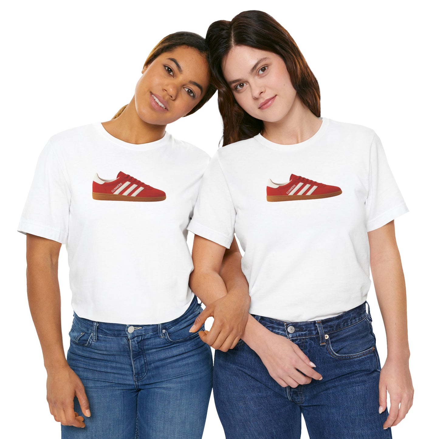Two women wearing white t-shirts with red sneaker print, standing close with arms linked, blue jeans