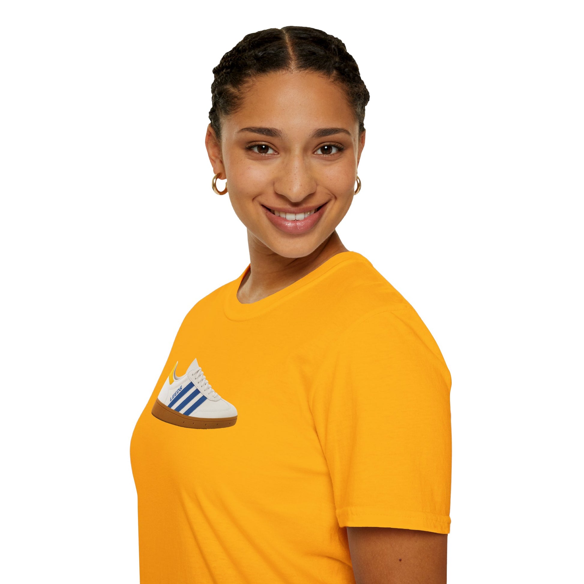 Smiling woman wearing a bright yellow t-shirt with a white sneaker graphic and blue stripes