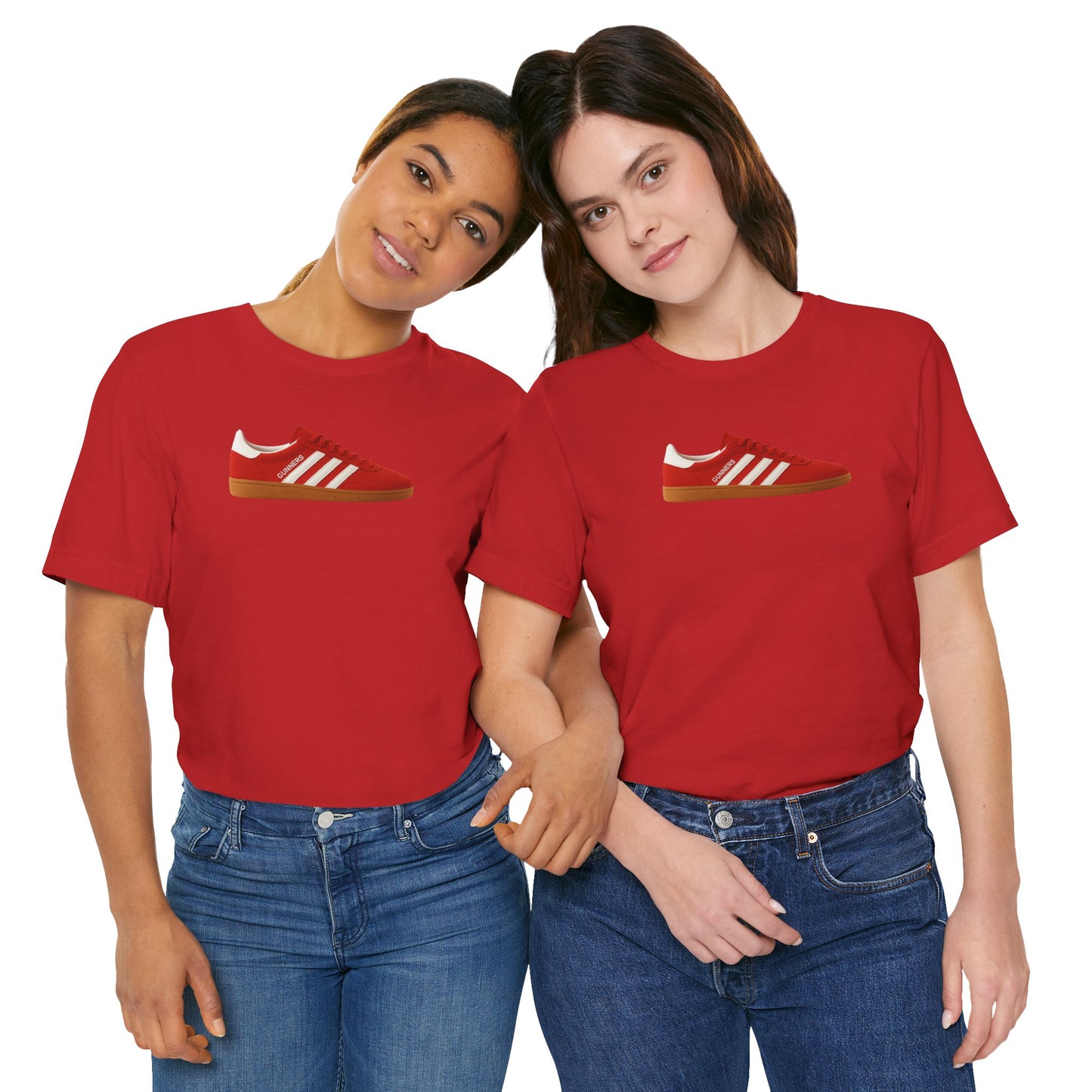 Two women wearing matching red t-shirts with red sneaker graphic, standing close and holding hands