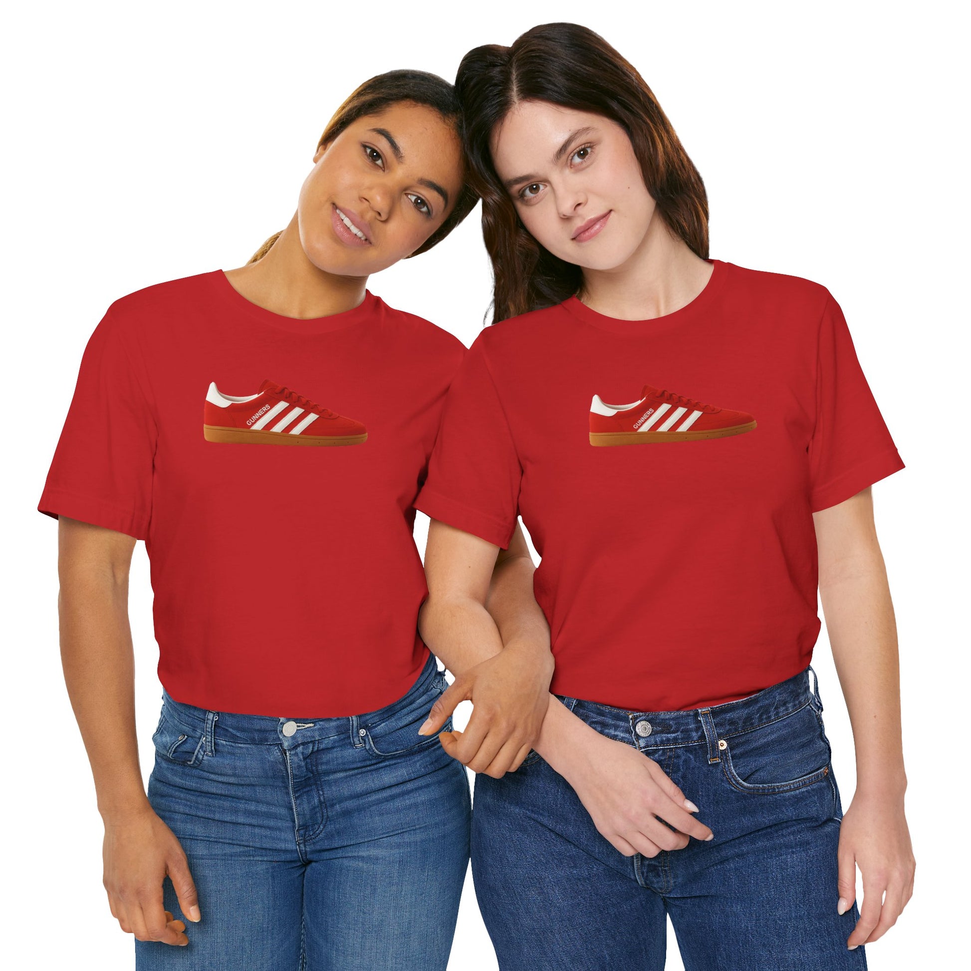Two women wearing matching red t-shirts with red sneaker graphic, standing close and holding hands