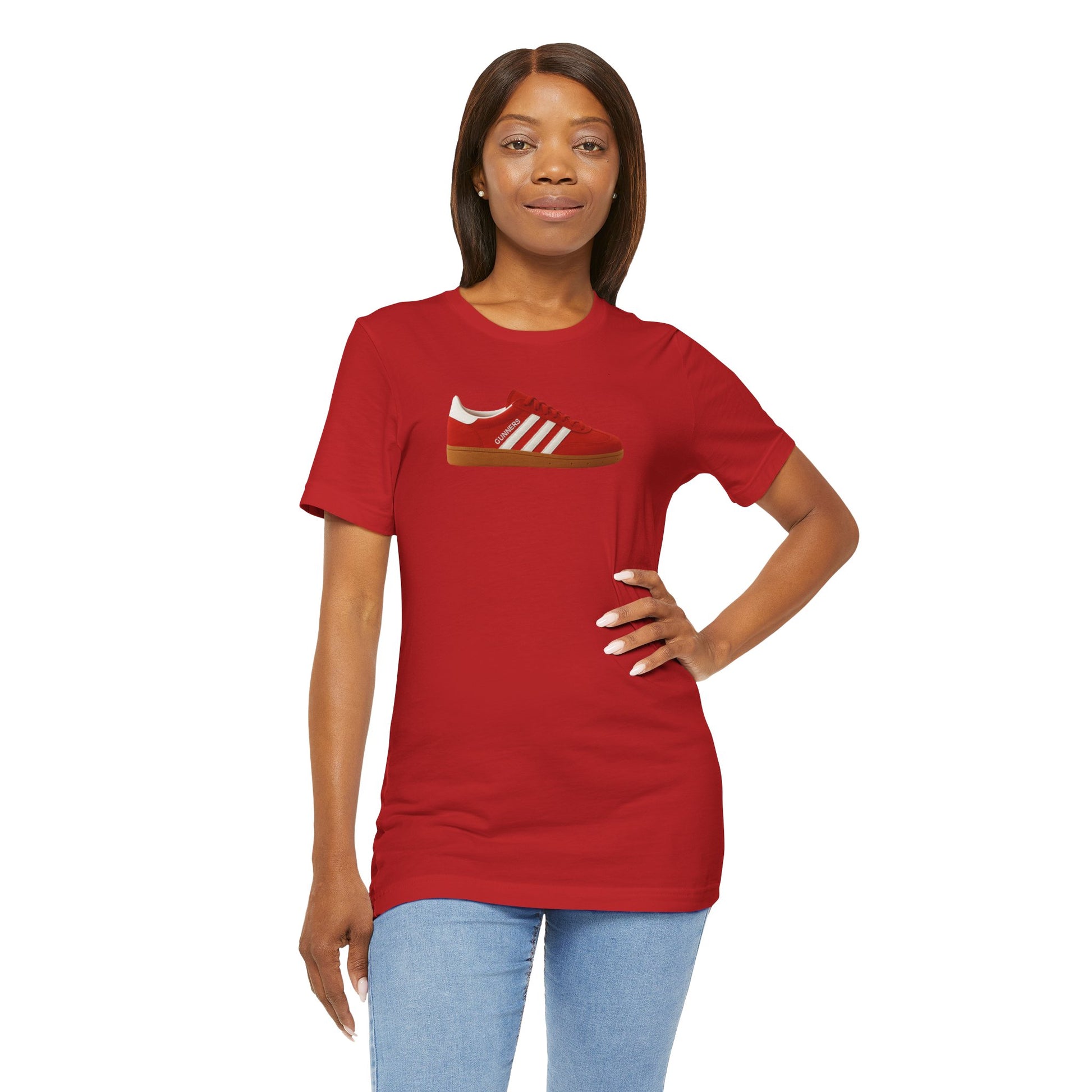 Woman wearing red T-shirt with red sneaker graphic and light blue jeans on white background
