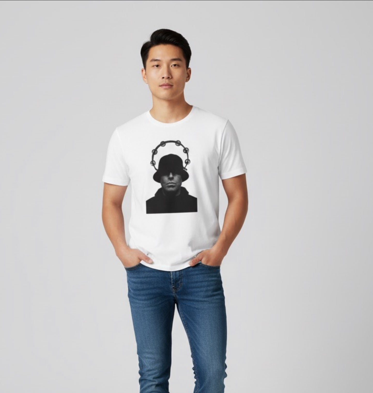 Man wearing white t-shirt with black graphic of person in hat and tambourine design, paired with blue jeans